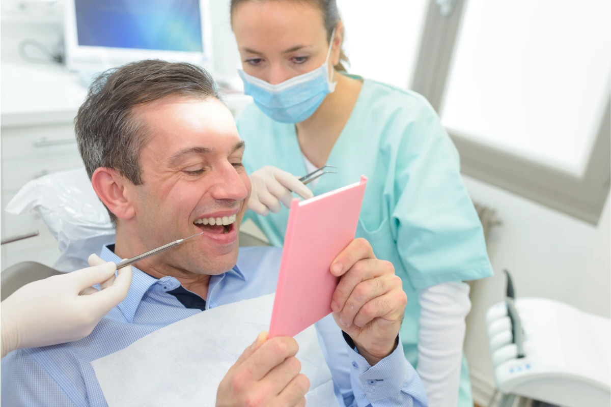 Patient reviewing a restored smile after receiving a dental crown following root canal treatment at Solomon Family Dentistry.